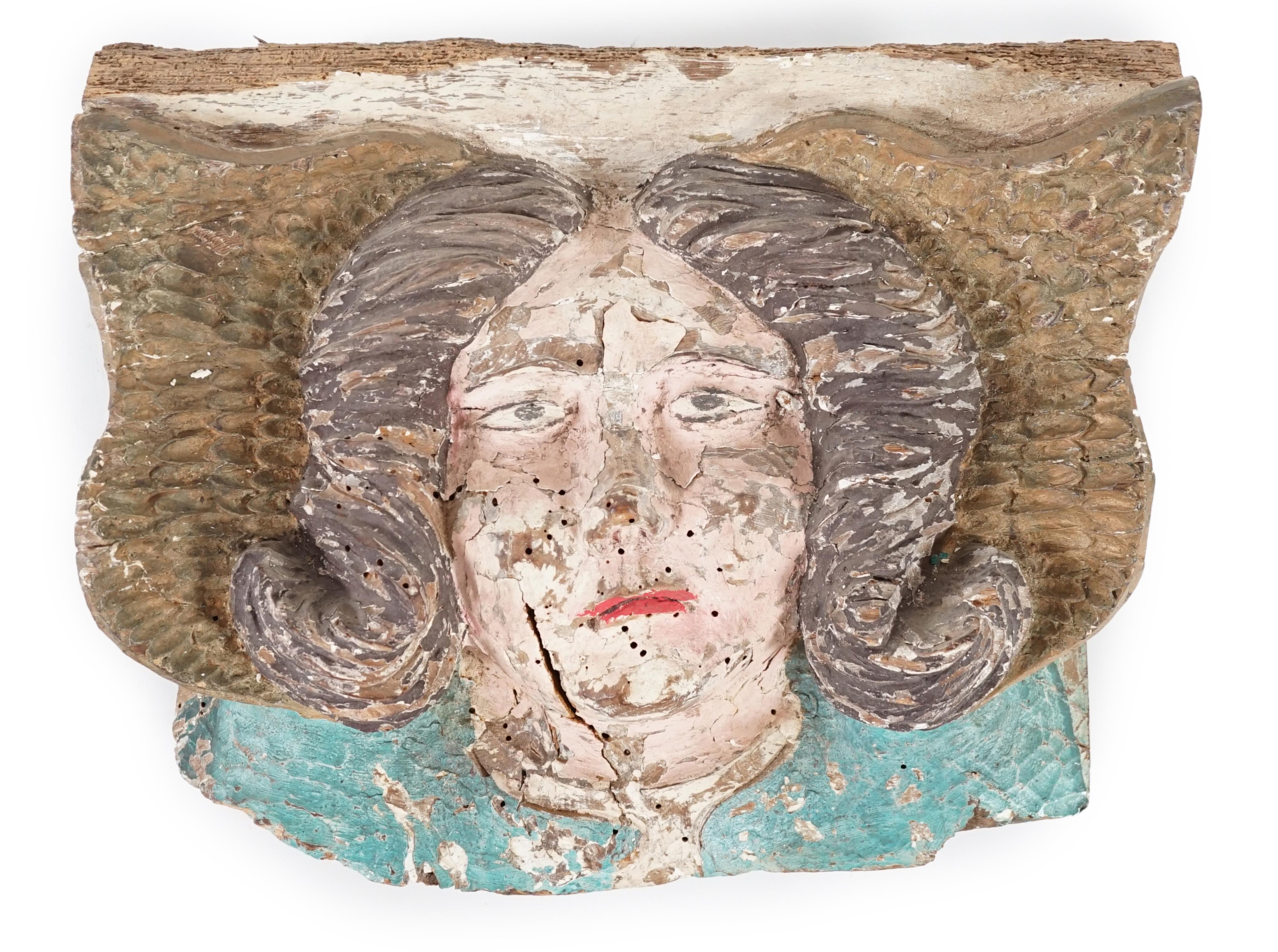 A 16th century French carved and painted wooden angel mask corbel